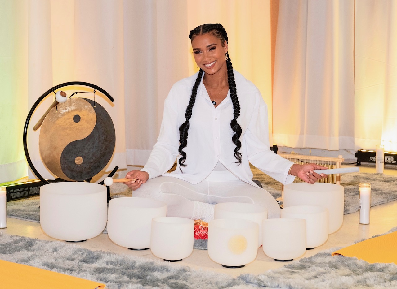 Victoria — Certified Sound Bath Practitioner, seated cross-legged with crystal singing bowls and gong